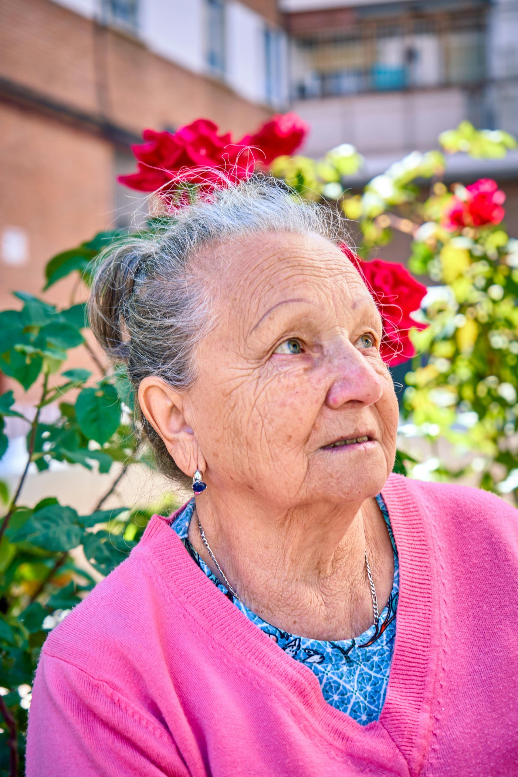 Senior woman enjoying a sunny day in a garden with roses in Islas Baleares, Spain.